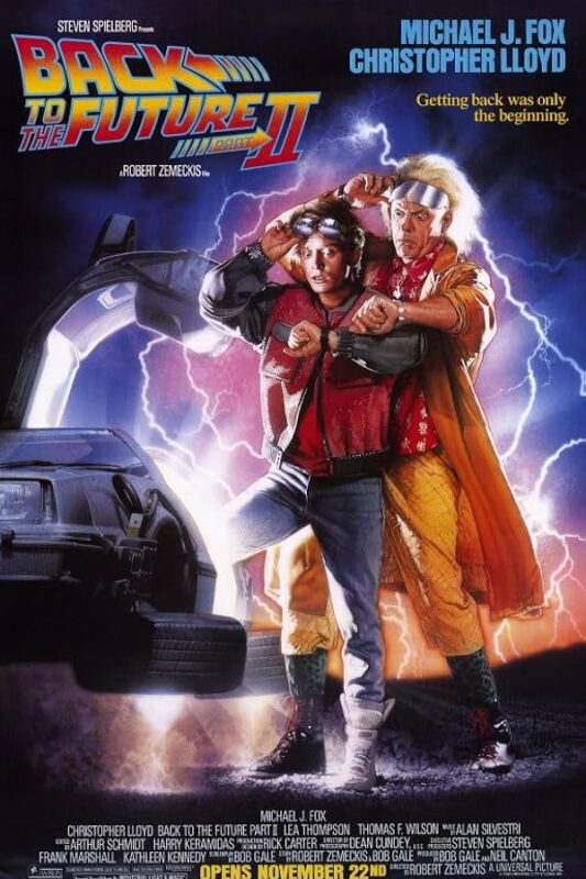 Two men posing before a lightning-struck DeLorean