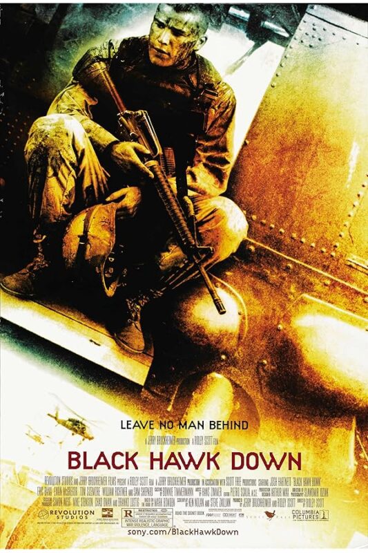 Soldier sitting on helicopter with rifle