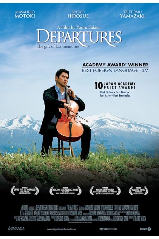 Man in suit seated outdoors playing cello