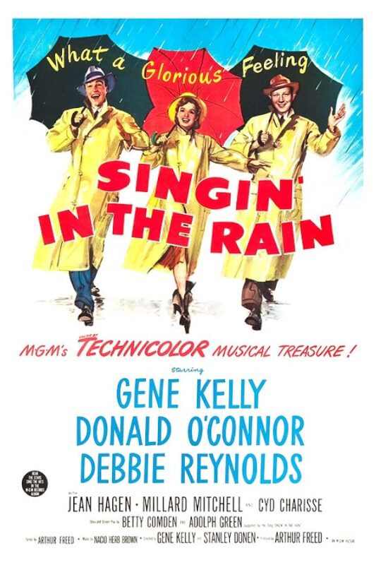 Three performers dancing with umbrellas, yellow raincoats.